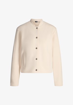 Veste couleur crème avec un col rond, des boutons argentés, deux poches latérales et une texture lisse. Design simple et droit.