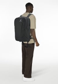 Schwarzer Rucksack aus strapazierfähigem Material, mit mehreren Reißverschlussfächern, gepolstertem Rücken und verstellbaren Schulterriemen.