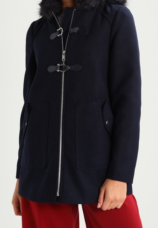 Marinblå kappa med huva i falsk päls, dragkedja, knappdetaljer och två framfickor. Tillverkad av mjukt tyg med en slät textur.