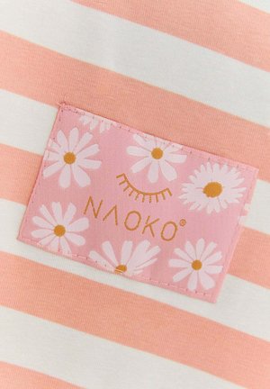 Pruhovaná látka v ružovej a bielej farbe s ružovou nášivkou s bielymi sedmikráskami a textom "NAOKO" v zlatej farbe. Hladká, ľahká textúra.