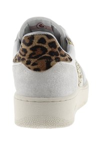 Sneaker bianco con pannello posteriore testurizzato caratterizzato da stampa leopardata. Dettagli in oro e suola liscia completano il design.