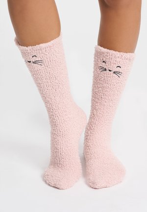 Pinke, flauschige Socken mit einer strukturierten Oberfläche, die ein dezentes Katzenkopfdesign zeigt, schwarze Nähten für die Schnurrhaare und einen gemütlichen Bund.