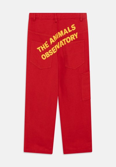 Pantalon cargo rouge avec le texte jaune "THE ANIMALS OBSERVATORY" au dos, comprenant deux poches arrière et une poche cargo sur le côté.