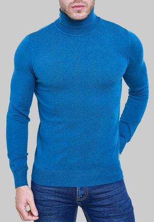 Pull à col roulé bleu en maille lisse, coupe ajustée, manches longues, poignets et ourlet côtelés, assorti avec un jean foncé.