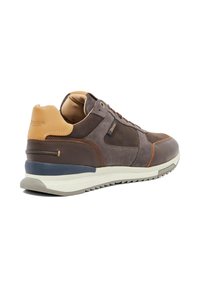 Men's brown sneaker featuring suede and leather materials, a beige heel cap, white midsole, and textured outsole. Distinctive branding detail present.