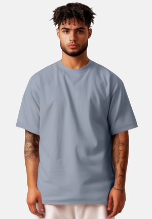 T-shirt oversize a maniche corte in cotone grigio chiaro, con scollo rotondo e vestibilità rilassata, dalla texture liscia e senza motivi distintivi.