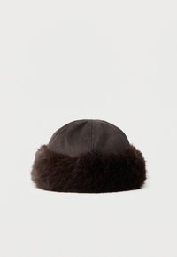 Σκούφος χειμερινός από σκουρό καφέ σουέντ με ευρεία, αφράτη γούνα γύρω από τη βάση, απεικονισμένος σε λευκό φόντο.