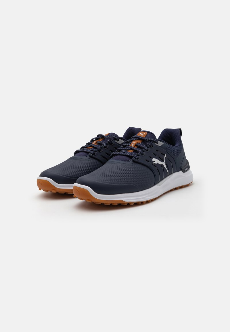 Marineblaue Sportschuhe mit Netzobermaterial, kontrastierenden orangen Akzenten, weißer Zwischensohle und strukturiertem braunem Gummiaußensohle für besseren Halt.