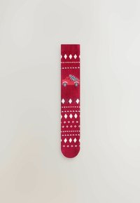Calcetines rojos con un pequeño coche rojo llevando un árbol de Navidad, adornados con patrones de diamantes y puntos blancos. Textura suave y diseño hasta el tobillo.