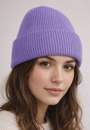 Young woman with long brown hair wearing a ribbed lavender beanie and a cream knit sweater, looking softly at the camera.