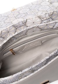 Borsa a tracolla in pelle grigia texturizzata con fodera a stampa geometrica, dotata di una tasca con zip e diversi scomparti per l'organizzazione. Accenti di hardware dorato.