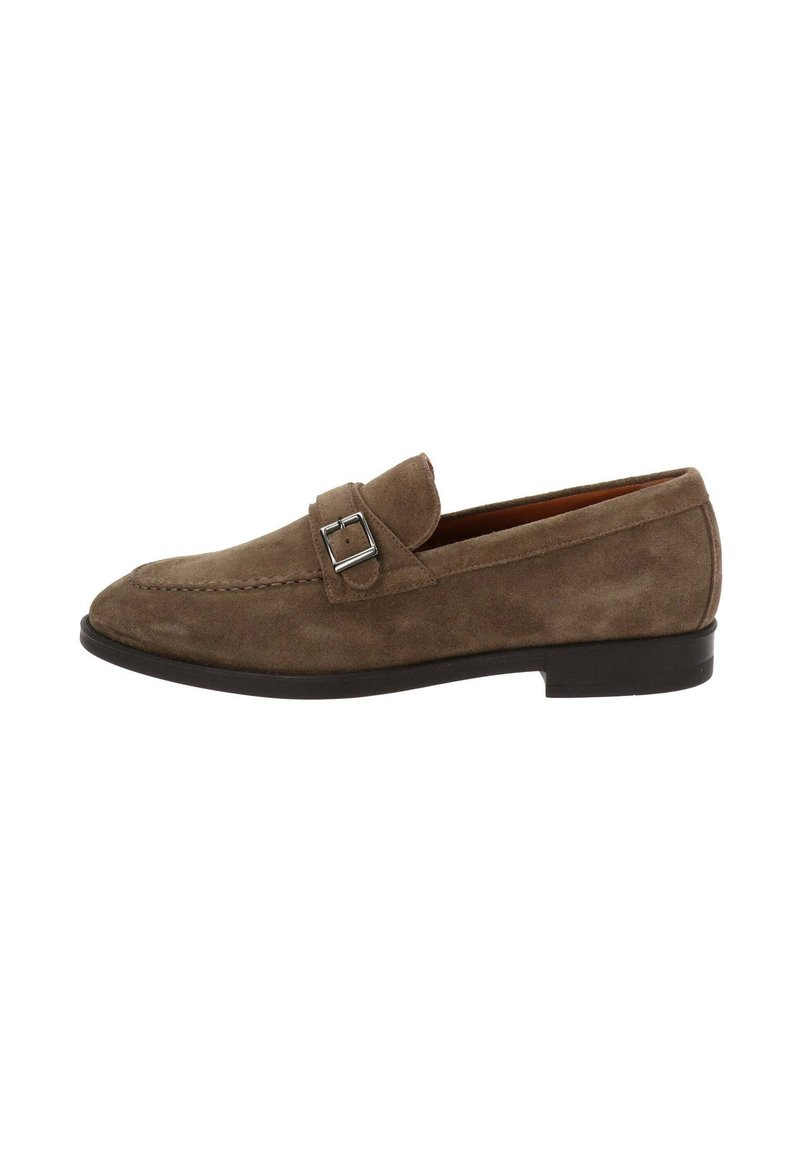 Mocassin en daim marron avec une semelle noire plate, détail de boucle métallique et accents de surpiqûre, présentant un bout pointu et un design à enfiler.
