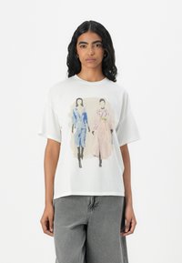 White oversized t-shirt featuring a printed illustration of two figures. Short sleeves, soft fabric, and a relaxed fit.