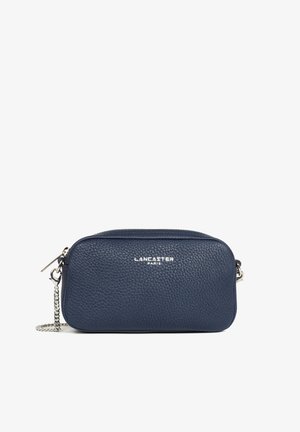 Sac bandoulière en cuir texturé bleu marine avec bandoulière chaîne argentée et fermeture éclair, logo « Lancaster Paris » centré sur le devant.