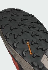 Semelle extérieure en caoutchouc noir avec un motif de semelle agressif. Marquage Continental en orange. Textures surélevées et rainures pour une traction et une stabilité optimales.