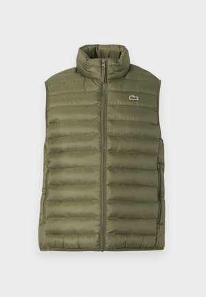Olive green padded vest with a high collar, full-length zipper, and small crocodile logo. Smooth texture with quilted sections.