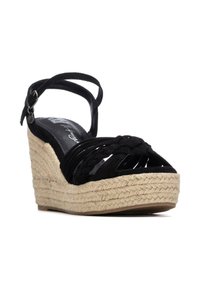 Sandalia de cuña negra con tiras trenzadas, hebilla en el tobillo y plataforma de suela tejida natural.