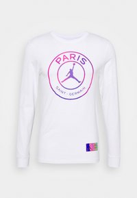 Vit långärmad skjorta med en cirkulär grafik som har texten "PARIS" och "SAINT-GERMAIN", samt en kontrasterande Jumpman-siluett i rosa och lila.