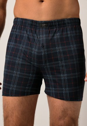Boxers de cuadro negro con patrones de cuadros azules y rojos, cinturilla elástica y un solo botón de cierre. Fabricados en material de algodón.