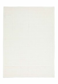 Bílá pletená deka s texturovaným mřížkovým vzorem, s hladkým okrajem a jemnou barevnou variací. Měří přibližně čtvercově.