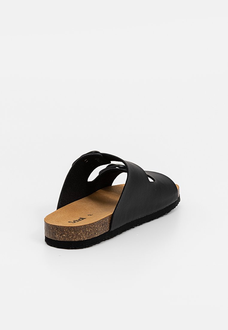Sandalo nero slip-on con plantare in sughero e due fasce larghe, vista angolata che mostra il lato interno e il tallone su sfondo bianco.
