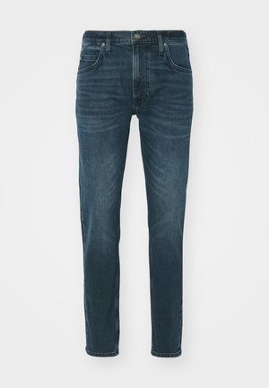 Sötétkék farmernadrág, slim fit fazonnal, öt zsebes kialakítással és finom kopásokkal az elején. Gombbal és cipzárral záródik.