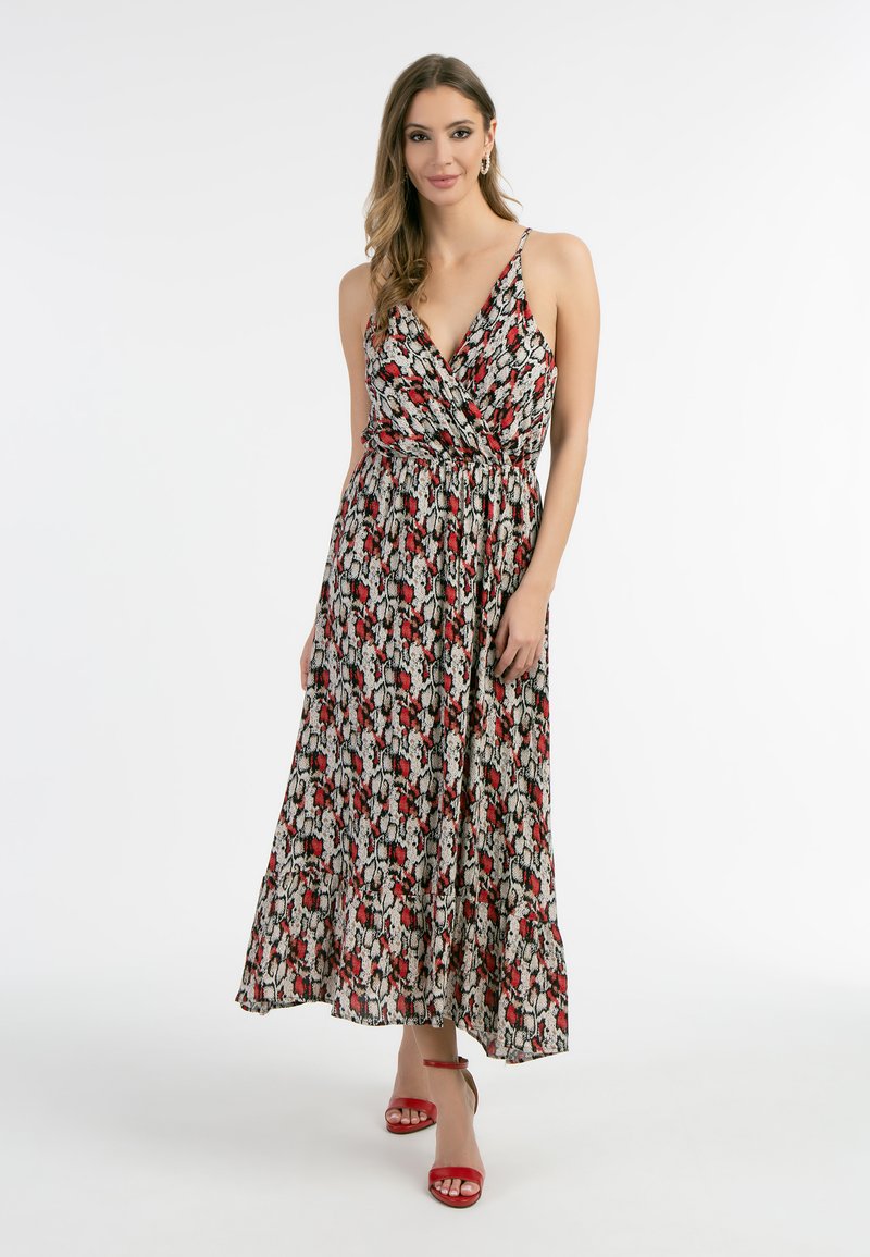 Rochie maxi cu un design înfășurat, cu un imprimeu multicolor în formă de șarpe. Dispune de bretele subțiri, talie ajustată și o fustă fluidă. Asortată cu tocuri roșii.