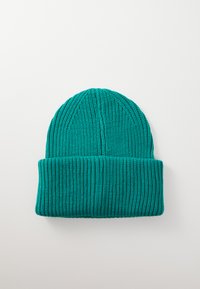 Teal knitted beanie with a ribbed texture, featuring a folded cuff and vertical stitch lines. Made of soft, stretchy material.