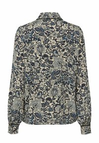 Blouse à manches longues avec un col montant, présentant un motif floral dense en noir, gris et bleu sur un fond beige clair.