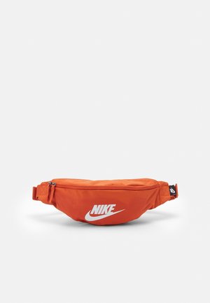 Knallig orange Nike-Gürteltasche mit weißem Logo, Reißverschluss-Hauptfach und verstellbarem Riemen, vor schlicht weißem Hintergrund.