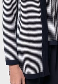 Randig stickad cardigan med marinblå och off-white vågräta ränder, ribbade ärmslut och en rak nederkant med en subtil textur.