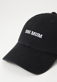 Zwarte katoenen baseballcap met witte geborduurde tekst "DOG MUM" op de voorkant, voorzien van een gebogen rand en een gestructureerde stof.