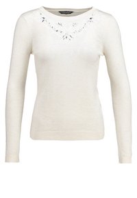 Pull crème à manches longues en matière douce, avec broderie décorative autour de l'encolure et poignets ainsi qu'ourlet côtelés.