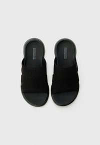 Zwarte instapsandalen met een bovenwerk van mesh-stof en een gestructureerde rubberen zool. Heeft een brede band over de middenvoet voor ondersteuning.
