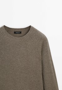 Pull en maille côtelée marron avec col rond et manches longues, avec une étiquette Massimo Dutti à l'intérieur du col.