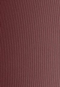 Tessuto a coste di un colore borgogna attenuato. La trama presenta linee verticali per un motivo sottile, creando un aspetto morbido e intrecciato.