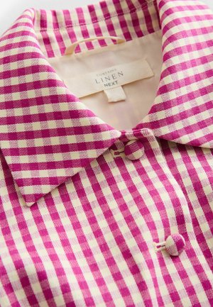 Leinenhemd mit karierter Musterung in Rosa und Creme. Verfügt über einen Kentkragen und Knopfleiste. Innenetikett mit Pflegehinweisen sichtbar.