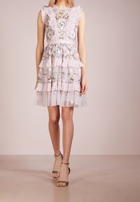 Lilac floral dress with layered tulle skirt, lace trim, and a fitted waist. Accented with delicate embroidery and off-white belt.