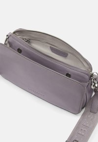 Purple leather crossbody bag featuring a zip closure, interior compartments, and a textured adjustable strap with embossed branding.