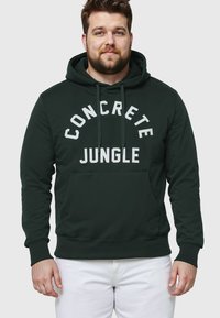 Ciemnozielona bluza z kapturem z nadrukiem "CONCRETE JUNGLE" w kolorze białym, posiada kieszeń z przodu, kaptur ze sznurkiem oraz ściągacze przy rękawach i u dołu.