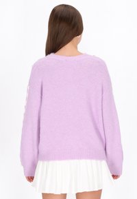 Lavenderfarbener, grob gestrickter Pullover mit lässigem Schnitt, ausgestattet mit geripptem Saum und Bündchen. Die weiche Textur und die langen Ärmel ergänzen einen weißen plissierten Rock.