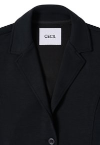 Zwarte blazer met een gestructureerde kraag, voorzien van een knoopsluiting en een label met de tekst "CECIL". Glad, lichtgewicht stof met een subtiele textuur.