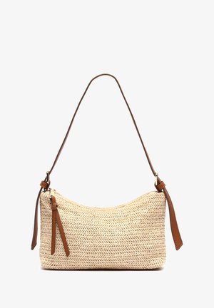 Woven straw shoulder bag with a natural color, curved shape, and a brown leather strap featuring adjustable hardware and decorative accents.