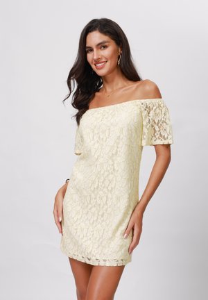 Off-shoulder blondekjole i lys gul, med korte blondeærmer, en tætsiddende silhuet og en scallop-kant.