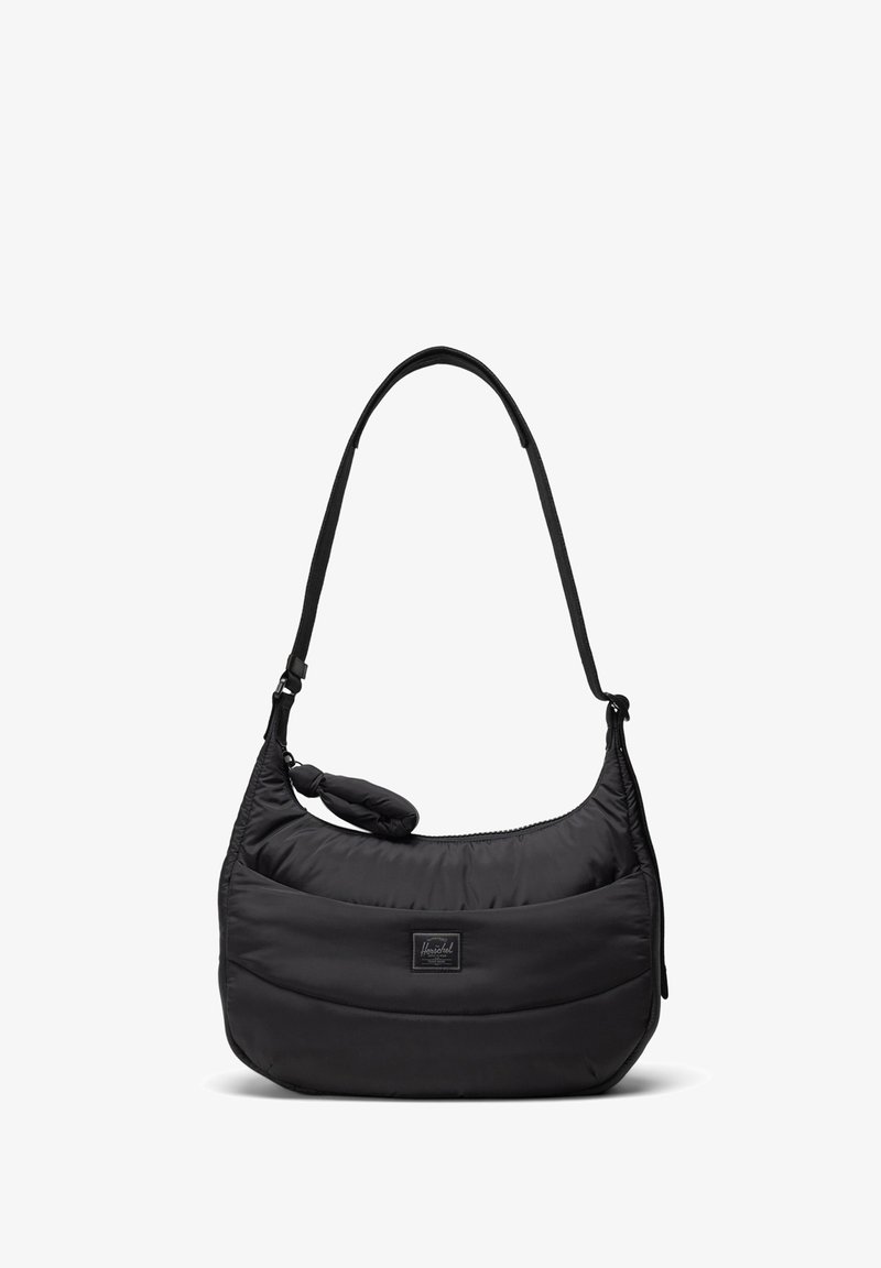 Bolso negro de hombro hecho de nylon acolchado con forma redondeada, que cuenta con una correa desmontable y una pequeña etiqueta frontal. Superficie lisa y texturizada.