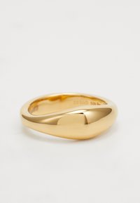 Anillo de oro con un diseño liso y redondeado y una ligera hendidura asimétrica. El acabado pulido realza su calidad reflectante.