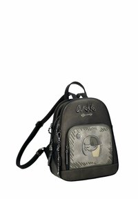 Mochila de cuero negro con un diseño redondeado, que cuenta con un bolsillo frontal gráfico, herrajes plateados y correas ajustables.