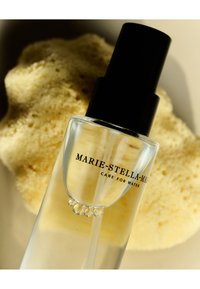 Klar glas sprayflaska med en svart pumpkupa, med en etikett som visar texten "MARIE-STELLA-MAR" i svart mot en ljus bakgrund.