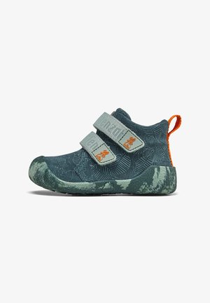 Chaussures pour enfants en bleu pétrole avec un motif de feuilles texturé, dotées de deux bandes Velcro grises et d'un onglet de talon orange vif.