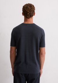 Granatowa koszulka z krótkim rękawem, dziana, o teksturowanym wykończeniu i jasnoszarych akcentach na mankietach, z okrągłym dekoltem i prostym dołem.